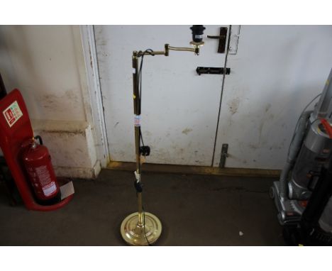 A brass standard lamp lacking shade