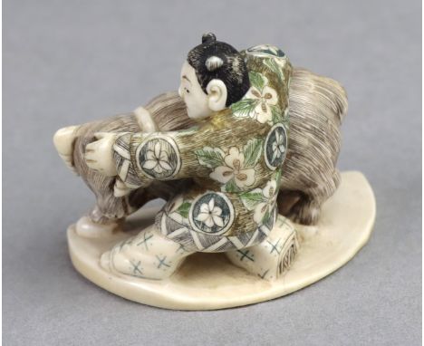 Netsuke, Japan um 1920 Elfenbein von Hand beschnitzt, partiell farbig verziert, signiert, mit Stier kämpfende Figur auf ovale