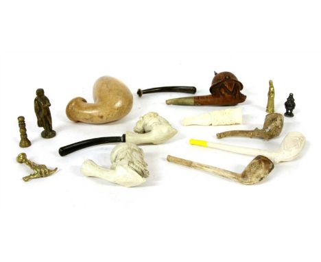 A collection of various pipes and pipe tampers, including a schweinhund pipe, modelled as a moustached pig wearing a pickelha