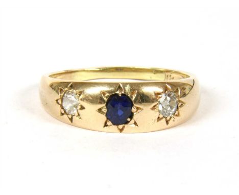 A gold sapphire and diamond three stone ring, with an oval mixed cut sapphire, with an old European cut diamond at each side,