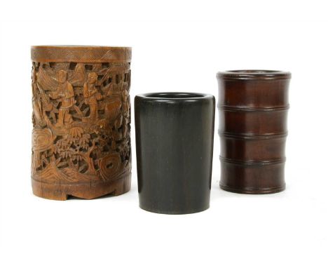 Three Chinese brush pots, comprising: one of bamboo, carved with figures in a garden, 13cm, the other two of wood, one with r