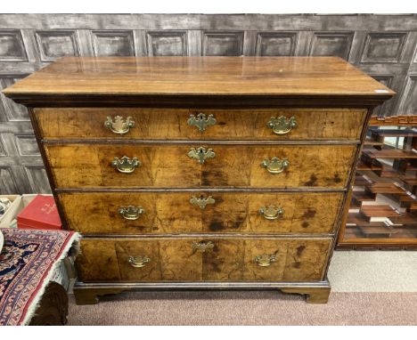 QUEEN ANNE WALNUT OBLONG CHEST of four long graduated cross banded drawers, with brass furniture, on later bracket feet and w
