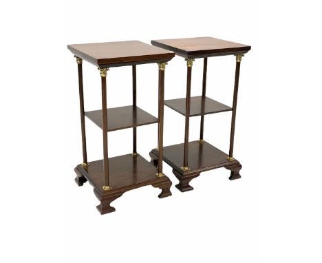 Pair of George III style mahogany lamp tables, three tiers on turned uprights with leaf cast brass capitols, raised on ogee b