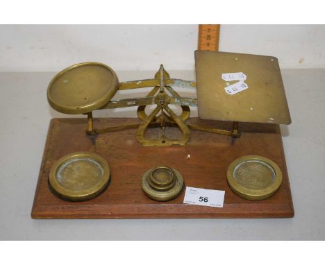 A pair of postal scales with some weights on rectangular wooden base