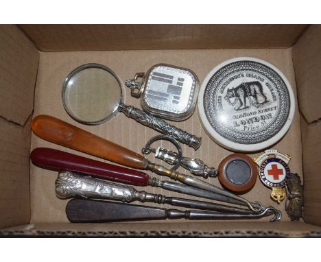 Box containing various items including a silver button hook, Red Cross enamel badge etc