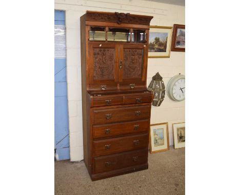 An early 20th Century dresser with four long and two short drawers with relief carved cupboards and mirror backed shelf above