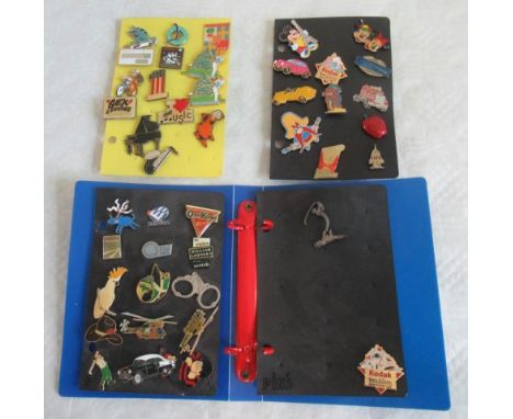 A small folder of enamel and other badges, including: Dennis the Menace, William Lawson Scotch Whisky, Euro Disney and others