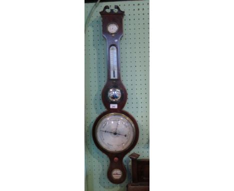 A mahogany and boxwood strung wheel barometer with dry/damp gauge and thermometer set to neck and silvered primary dial.
