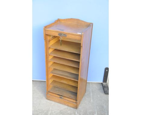 20th C oak office cabinet with raised back and sides and roller shutter door and sliding pull out drawers (98cm x 43cm x 33cm
