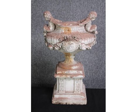 A concrete classical planter mounted with two cherubs on either side. H.46 cm. 