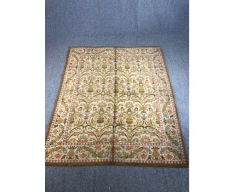 An Eastern woollen carpet with repeating scrolling foliate motifs across the pale primrose field within floral borders. L.240