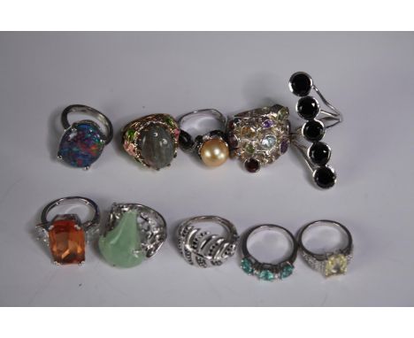 A collection of ten silver gem-set rings of various designs. Set with peridot, pearl, amethyst and opal doublet. Stamped 925.