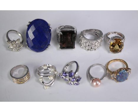 A collection of ten silver gem-set rings of various designs. Set with peridot, Tanzanite, Lapis lazuli and opal triplet. Stam