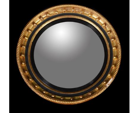 A Regency giltwood convex wall mirror, circa 1820, with ropetwist frame and ebonised slip, 65cm diameterCondition Report: Mar