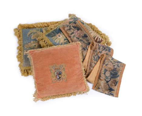 A pair of cushions, with verdure tapestry fragment facings, 40cm square, together with a further cushion with central armoria