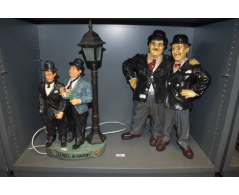 A modern figure base set of Stan Laurel and Oliver Hardy with a similar designed lamp base