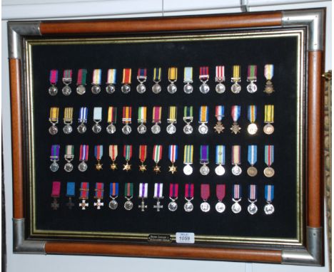 A framed display of 60 copy half scale British Gallantry and Campaign medals by Danbury Mint together with a laminated descri