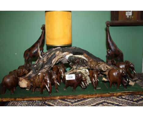 A display of wooden carved Animals including giraffes, elephants etc, with birds and lion, etc. and a candlestick fitting to 