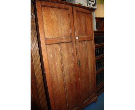 A 1940's Oak fitted double doored ''Alwyn'' Wardrobe, having moulded cornice over the pair of opposing three panel doors with