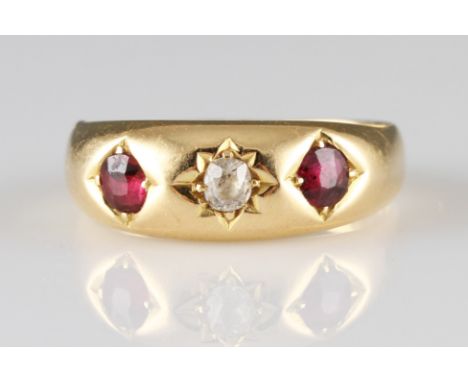 A Victorian 18ct yellow gold diamond and ruby three stone ring, star set with a central old cushion cut diamond, flanked to e