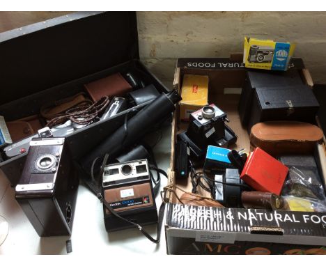 A box of various cameras including Polaroid Colorpack 80, Fafix projector, Kodak Brownie 127, Kodak Ek100 instant camera, Tam