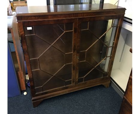 A mahogany astra-glazed two door display cabinet on bracket feet.