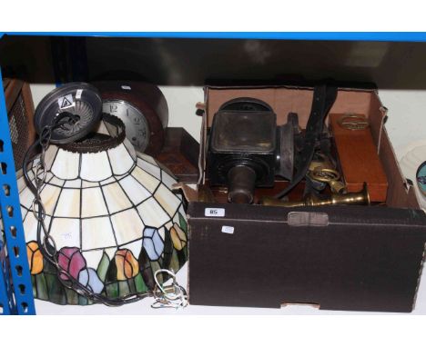 Box of metalwares, glass Tiffany style light shade, horsebrasses, leathers, coach lamp, candlesticks.