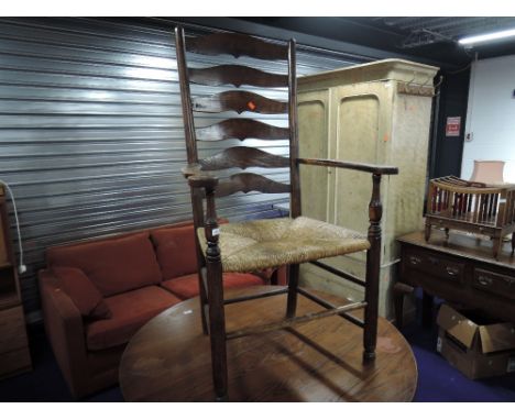 A traditional oak ladder back rush seated country carver chair