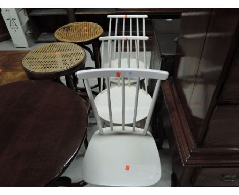 A set of three vintage painted kitchen chairs having rail and stick backs, in the Ercol style