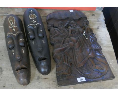 Pair of carved tribal masks inlaid with mother of pearl together with carved tribal plaque 