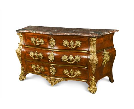 the shaped red brèche marble top above three long drawers, the corner mounts with a dolphin flanked by two blowing figures of