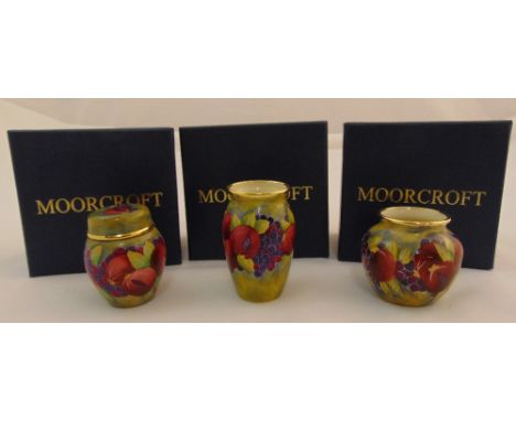 Moorcroft enamel miniatures to include three vases decorated with fruits and flowers, one with pull off cover, marks to the b