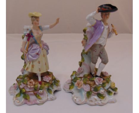 A pair of Sitzendorf candlesticks with applied figures of a man and lady on floral bases, marks to the bases, tallest 20cm (h