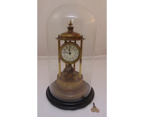 A brass skeleton clock, white enamel dial, Arabic numerals, mounted in a glass dome to include key and pendulum, 50cm (h)