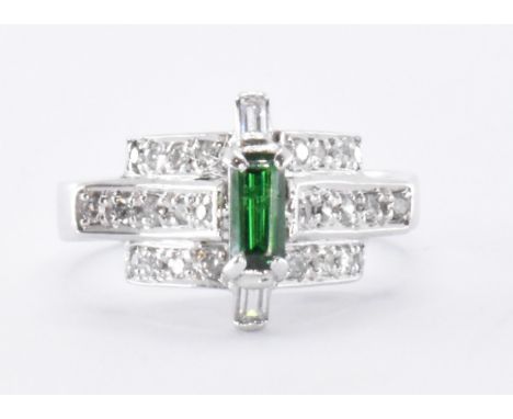 An 18ct white gold diamond and green tourmaline Art Deco style ring. The ring having a central baguette cut tourmaline flanke