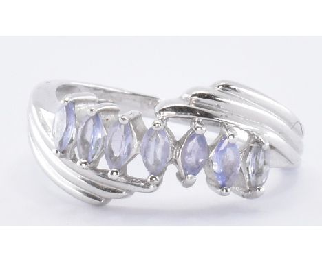 A hallmarked 9ct white gold crossover ring being set with seven marquise cut purple stones. Hallmarked Birmingham 2006. Weigh