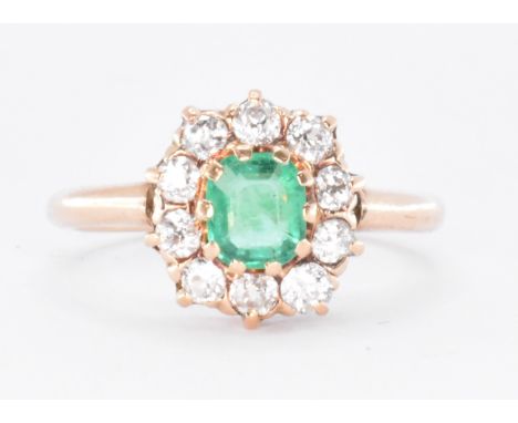 A 14ct gold emerald and diamond cluster ring being set with a cushion cut emerald with a halo of old cut diamonds. Marked 585