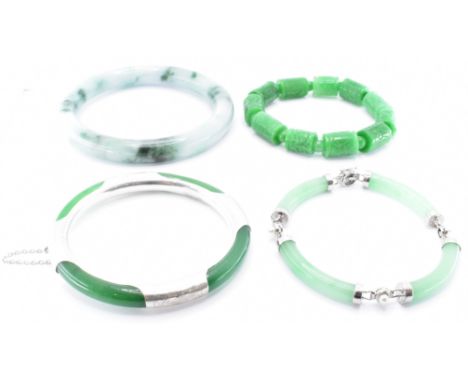 A group of four Chinese jade hard stone bracelets to include a bangle, a bracelet with alternate cylindrical and round beads,