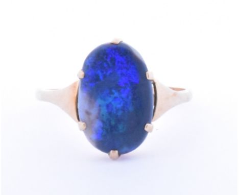 A 9ct gold and opal dress ring. The ring set with an oval cut panel of opal exhibiting blue and green play of colour.&nbsp; M