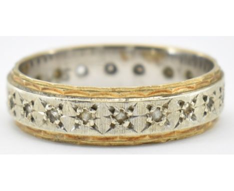 A hallmarked 9ct two tone gold and white stone eternity ring. The ring set with round cut white stones in star settings frame