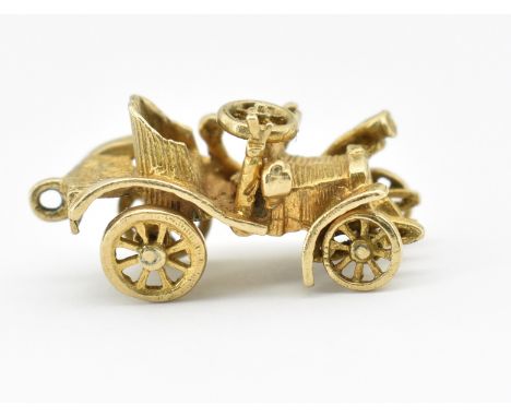 A hallmarked 9ct gold bracelet car charm. The charm in the form of a vintage car having turning wheels. Hallmarked London. We