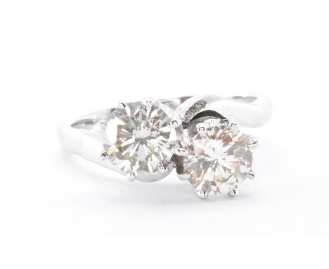 An 18ct white gold and diamond crossover ring. The ring having two two round cut diamonds within prong settings. Ring size K.