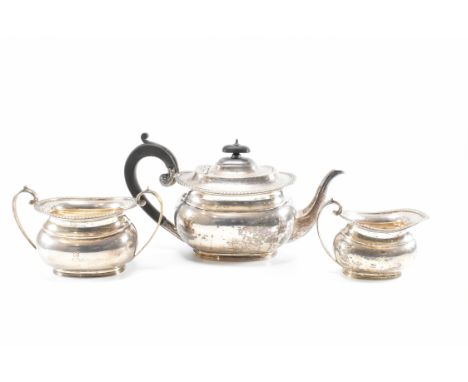 A 1920s Art Deco era silver hallmarked 3-piece tea service comprising teapot, sugar bowl and creamer. The tea pot having an e