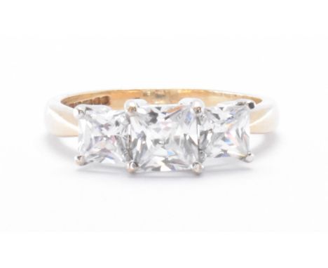 A hallmarked 9ct gold three stone ring. The ring set with three graduating princess cut square CZ stones in prong settings. H