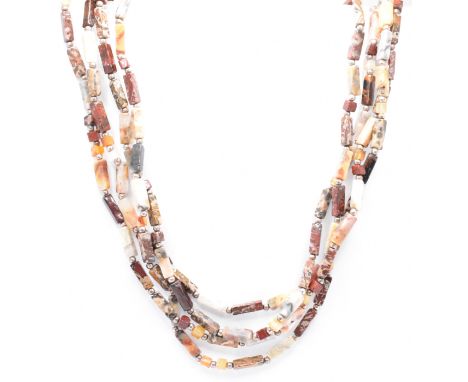 A four strand necklace threaded with rectangular polished stone beads with white metal spacer beads, all mounted to a silver 