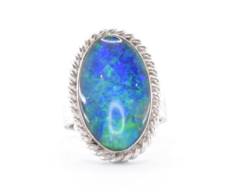 A vintage white metal and opal doublet ring The ring set with an oval opal panel within a rope twist border on a textured ban