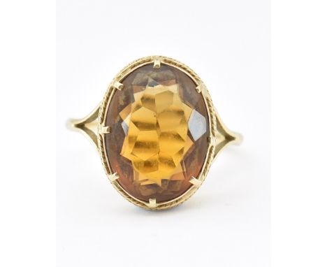 A 9ct gold and citrine dress ring. The ring set with an oval mixed cut citrine in a bezel and prong setting having bifurcated