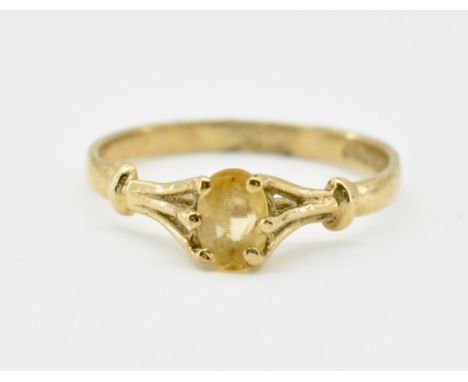 A hallmarked 9ct gold and topaz ring. The ring having a oval cut topaz prong set with tri wire shoulders to plain shank. Hall