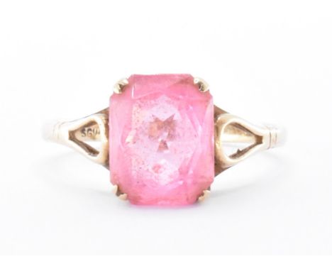 A 9ct gold and pink stone ring. The ring being set with a rectangular cut pink stone on pierced shoulders. Marked 9ct. Weight