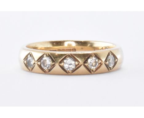 A hallmarked 9ct gold and diamond band ring. The ring set with 5 round brilliant cut diamonds to D. shaped band. Estimated Di